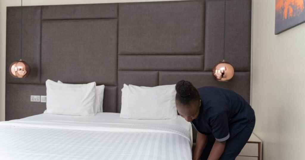 Woman making a bed with fresh linens - Airbnb and Short-Term Rental Laundry Turnover in Chicago